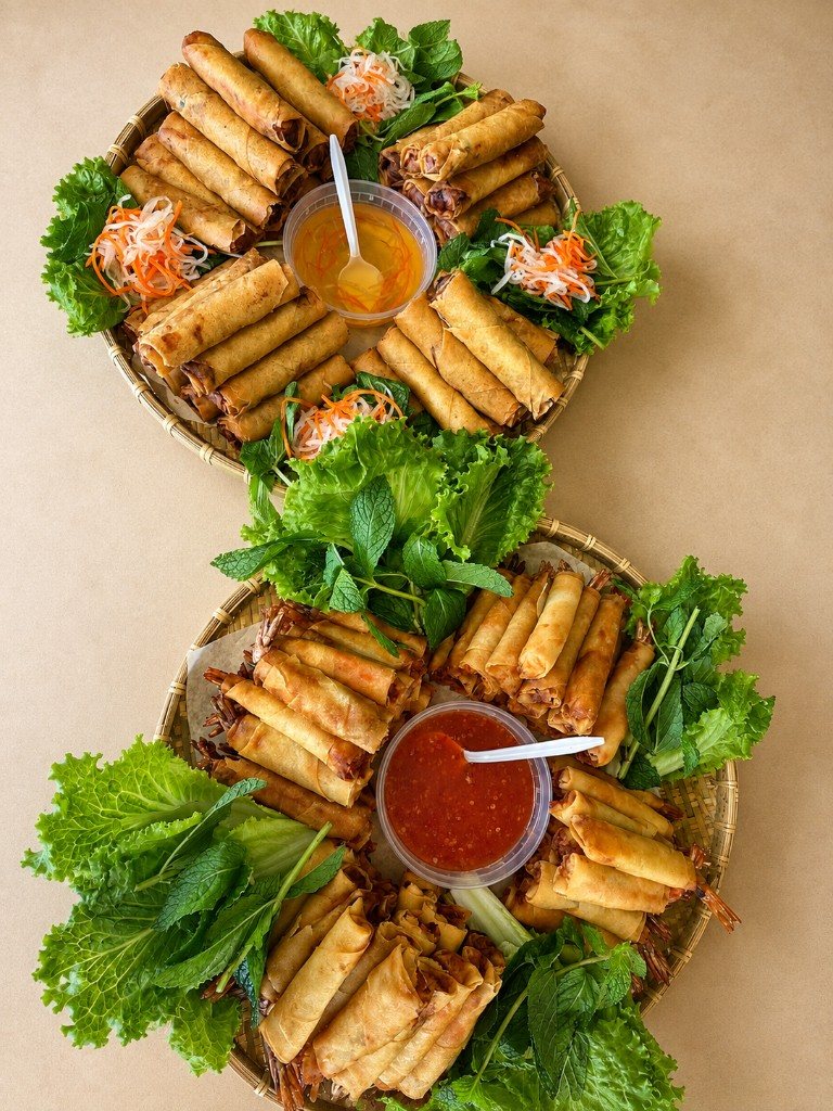 Fried egg rolls and shrimp rolls on catering platters